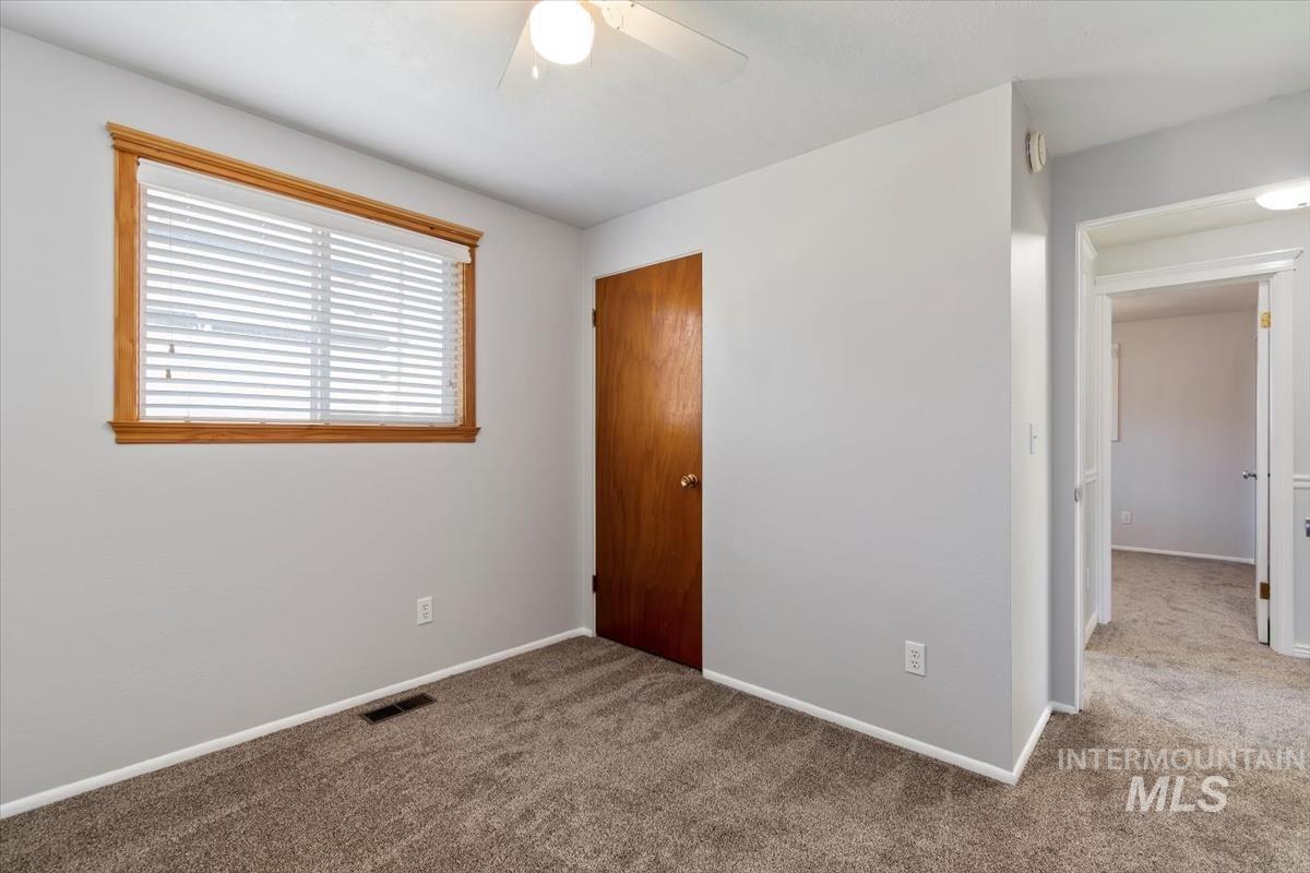 Unfurnished bedroom with a closet, carpet, and a ceiling fan