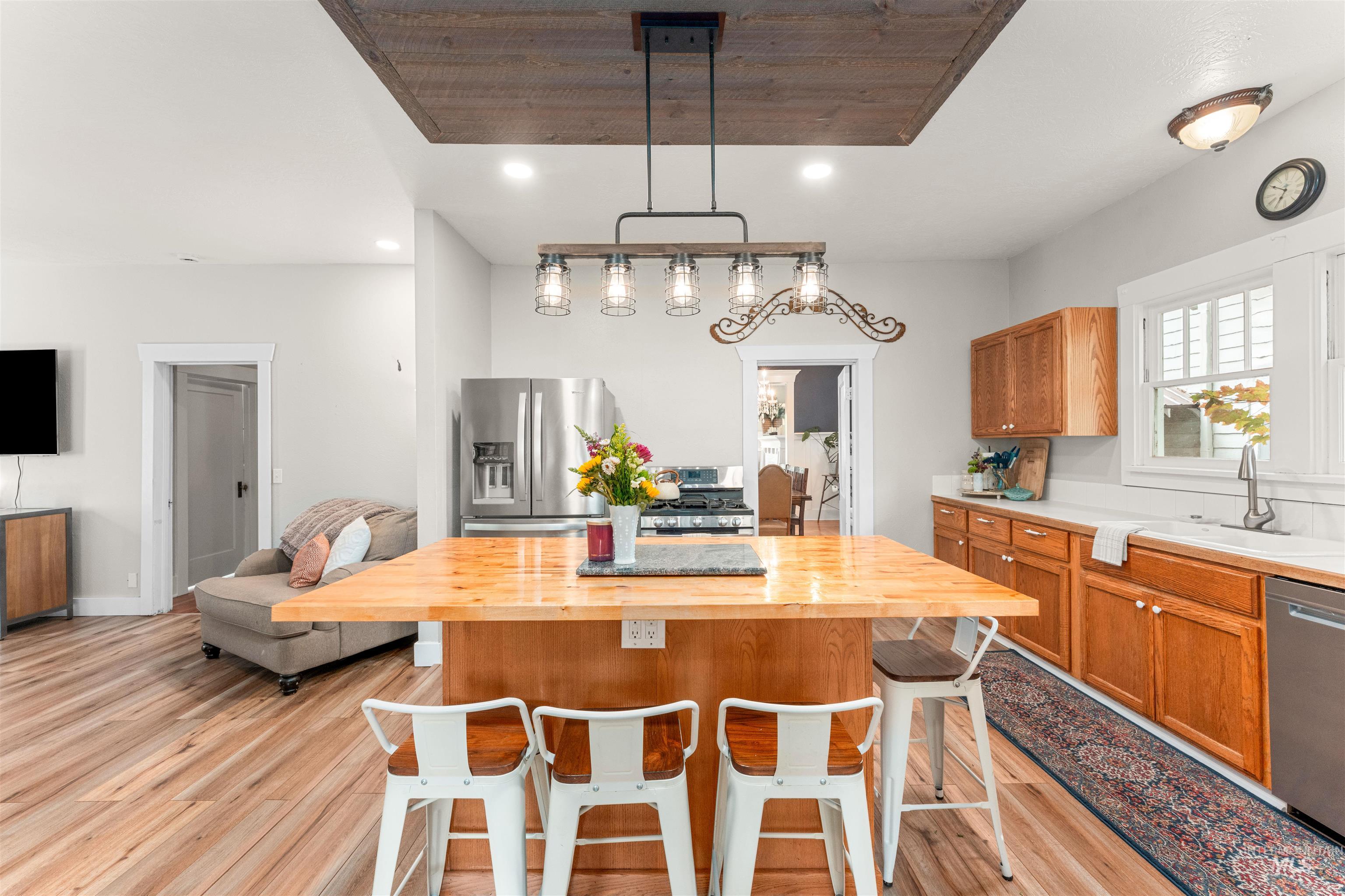 Kitchen with brown cabinetry, a kitchen breakfast bar, wooden counters, light wood finished floors, and stainless steel appliances