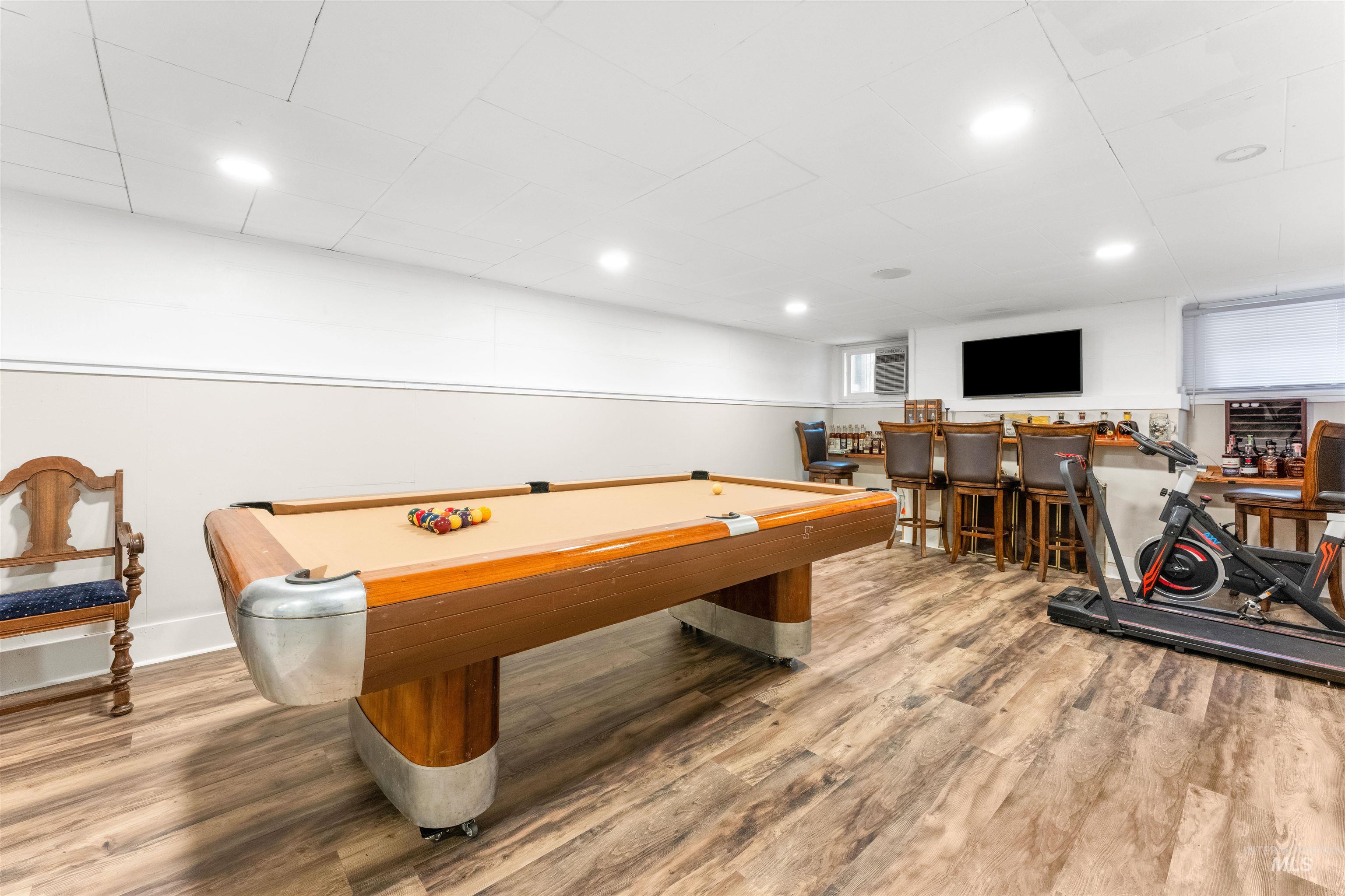Game room featuring billiards table, light wood-style floors, bar area, and recessed lighting