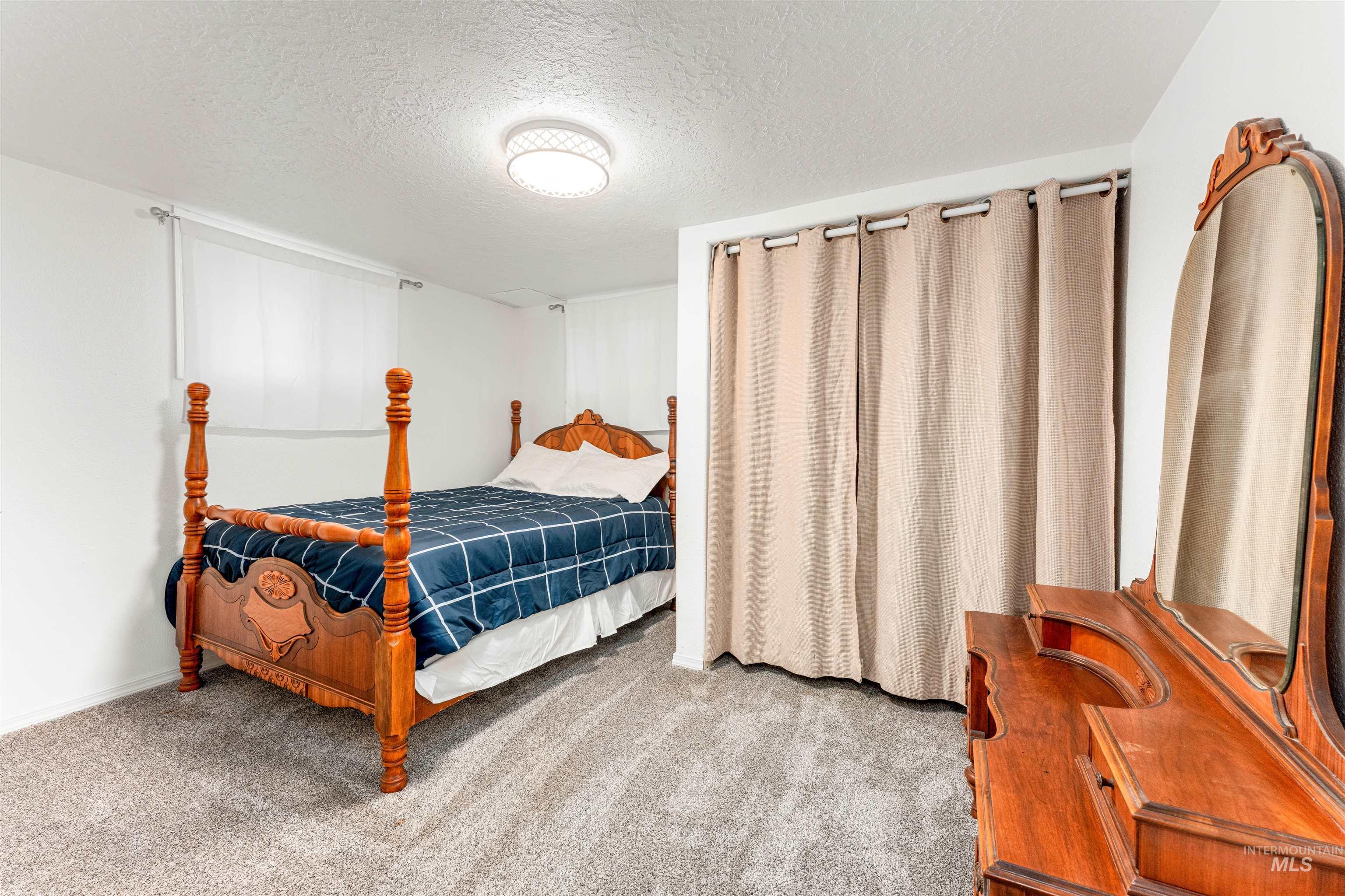 Carpeted bedroom with a textured ceiling
