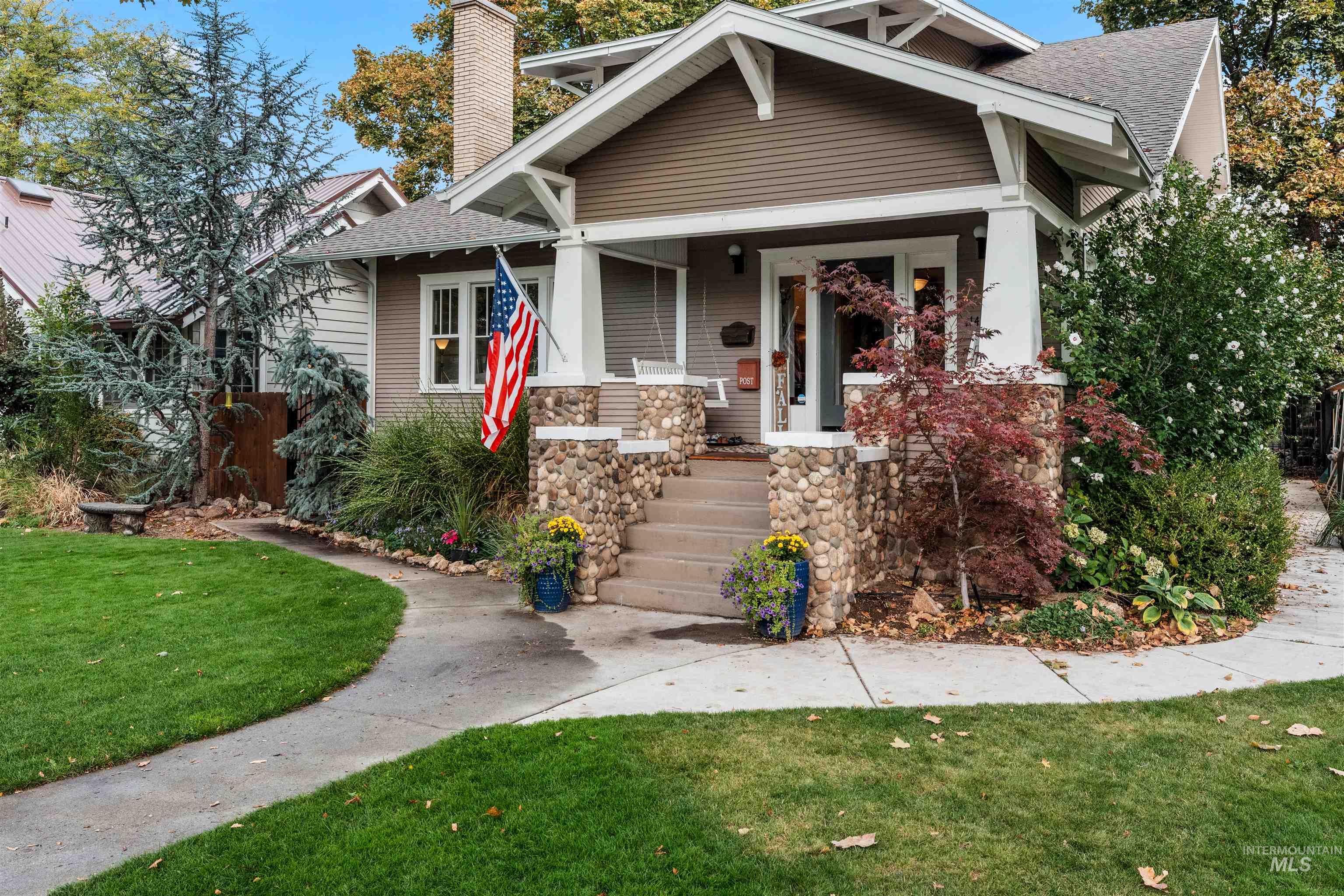 Bungalow featuring a front yard, covered porch, and roof with shingles
