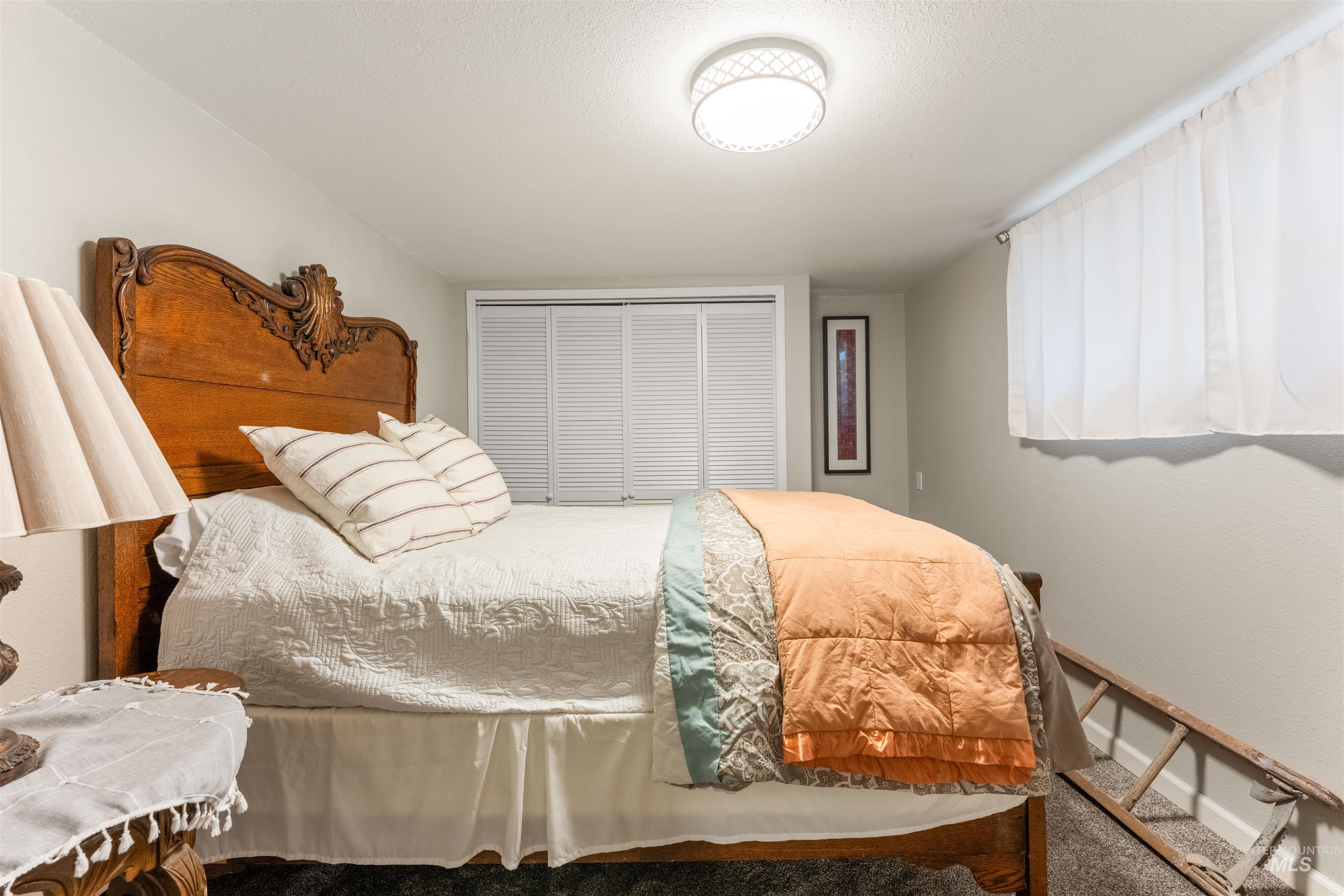 Carpeted bedroom with a closet and baseboards