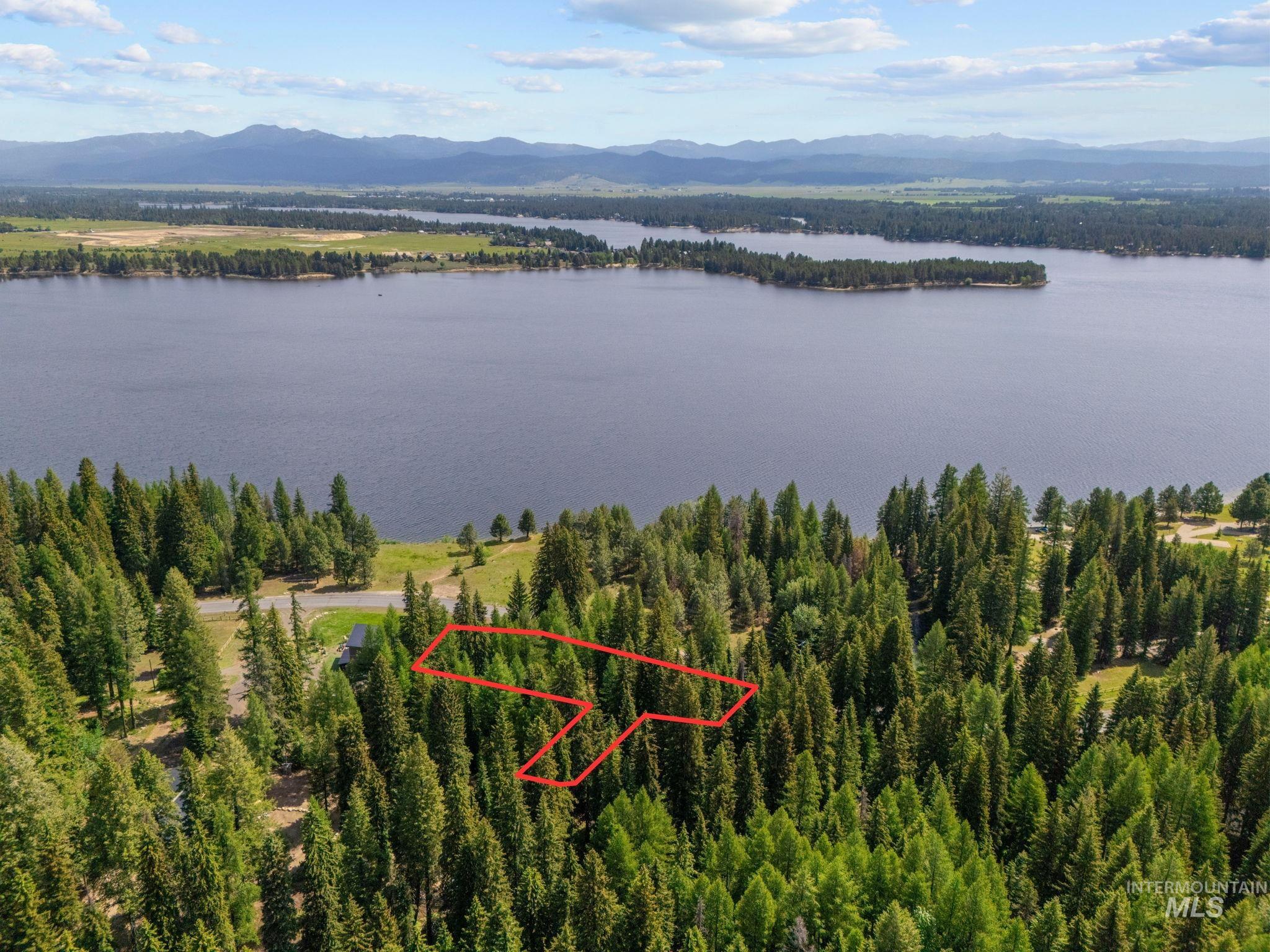 Aerial overview of property's location with a water and mountain view and property parcel outlined