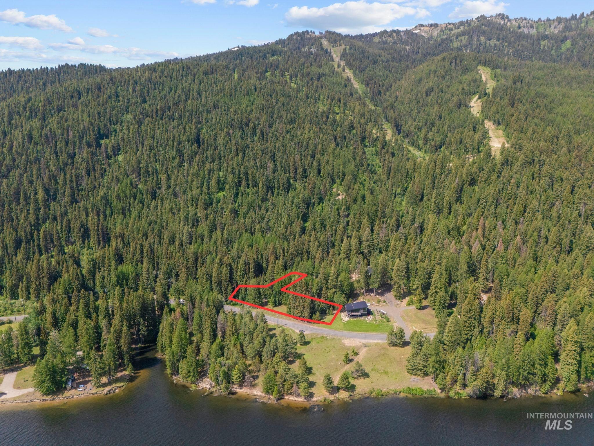 Aerial overview of property's location with property boundaries highlighted and a water and mountain view
