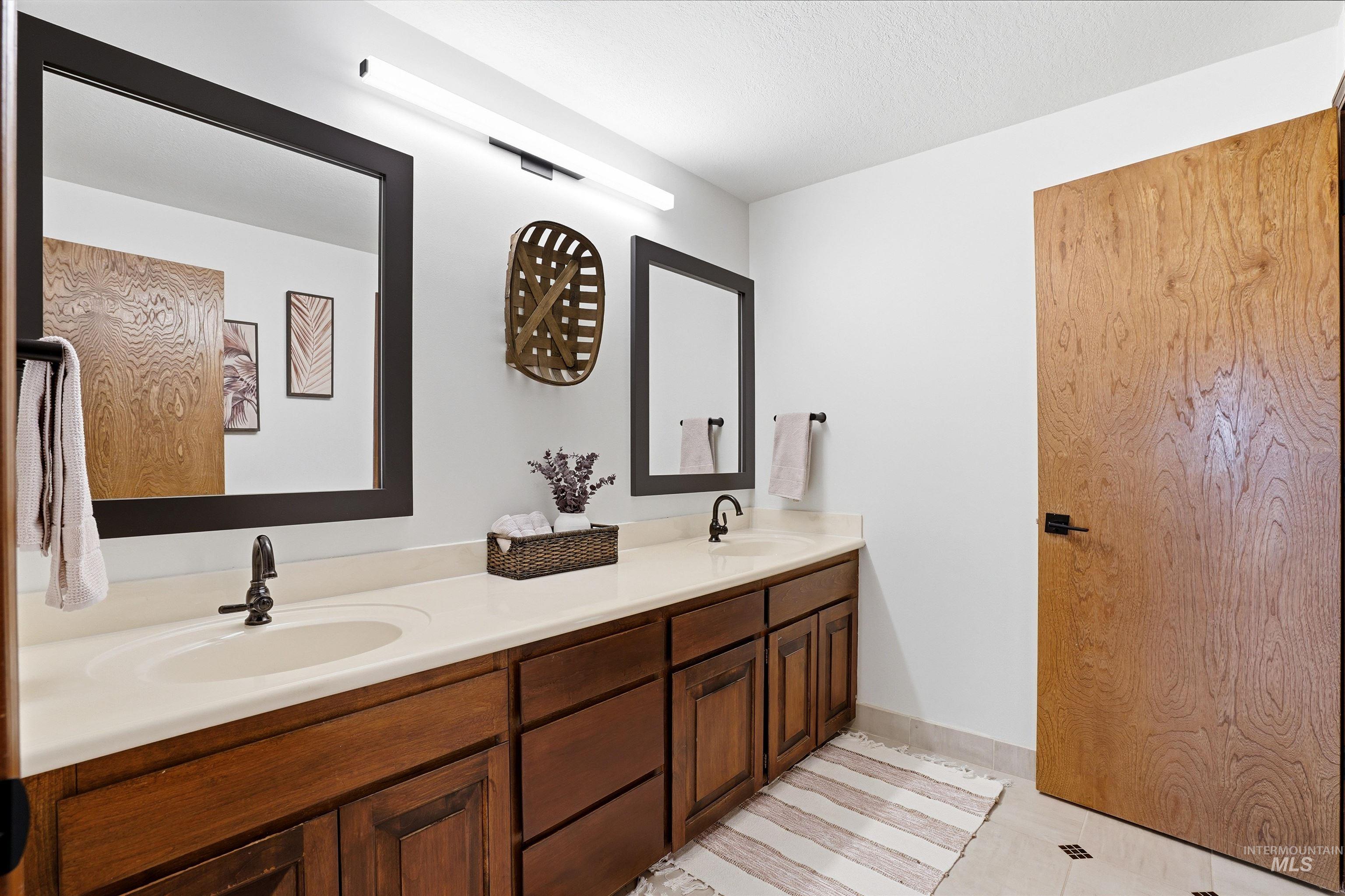 Bathroom with double vanity and a textured ceiling