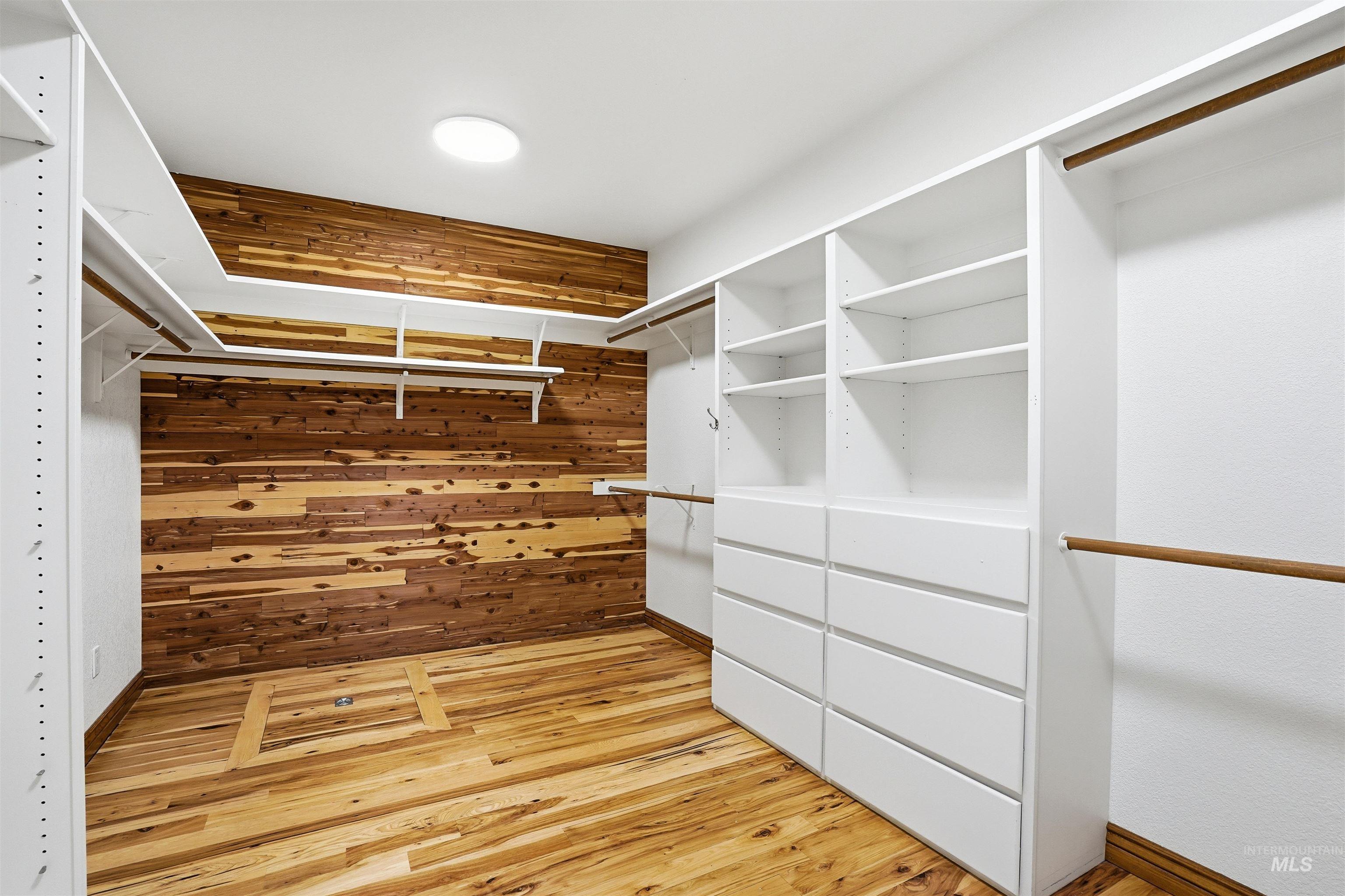 Walk in closet with light wood-style floors