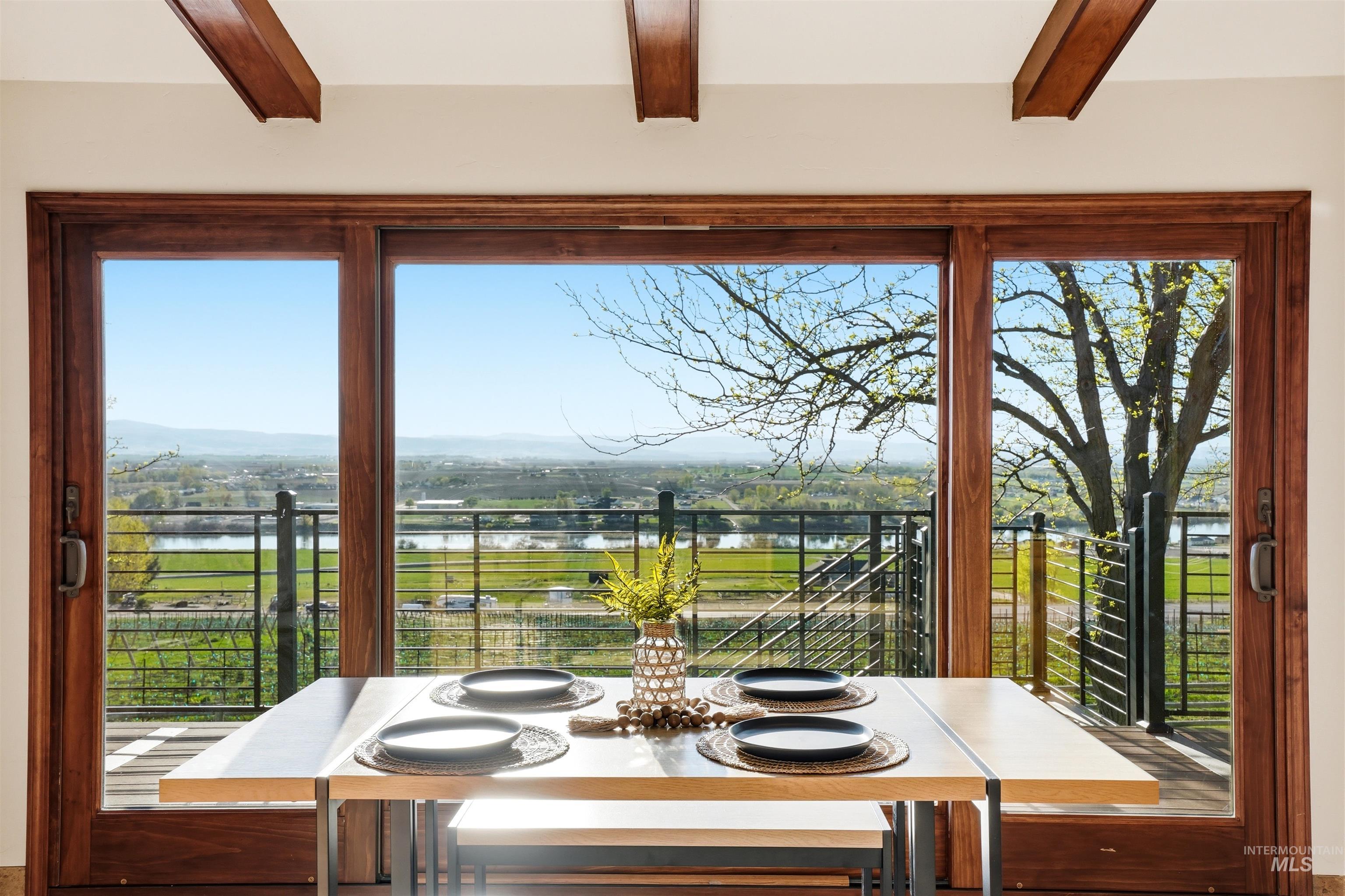 Dining space featuring a water view and beamed ceiling
