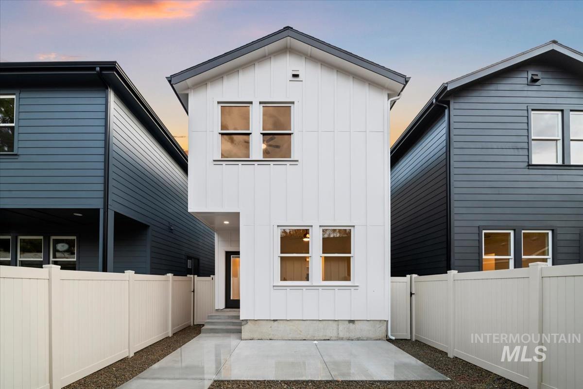 Rear view of property featuring board and batten siding and a fenced backyard