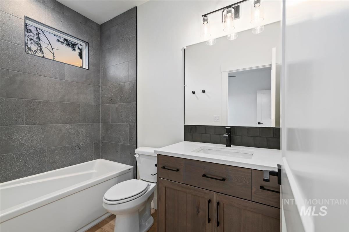 Full bath with vanity, shower / washtub combination, and decorative backsplash