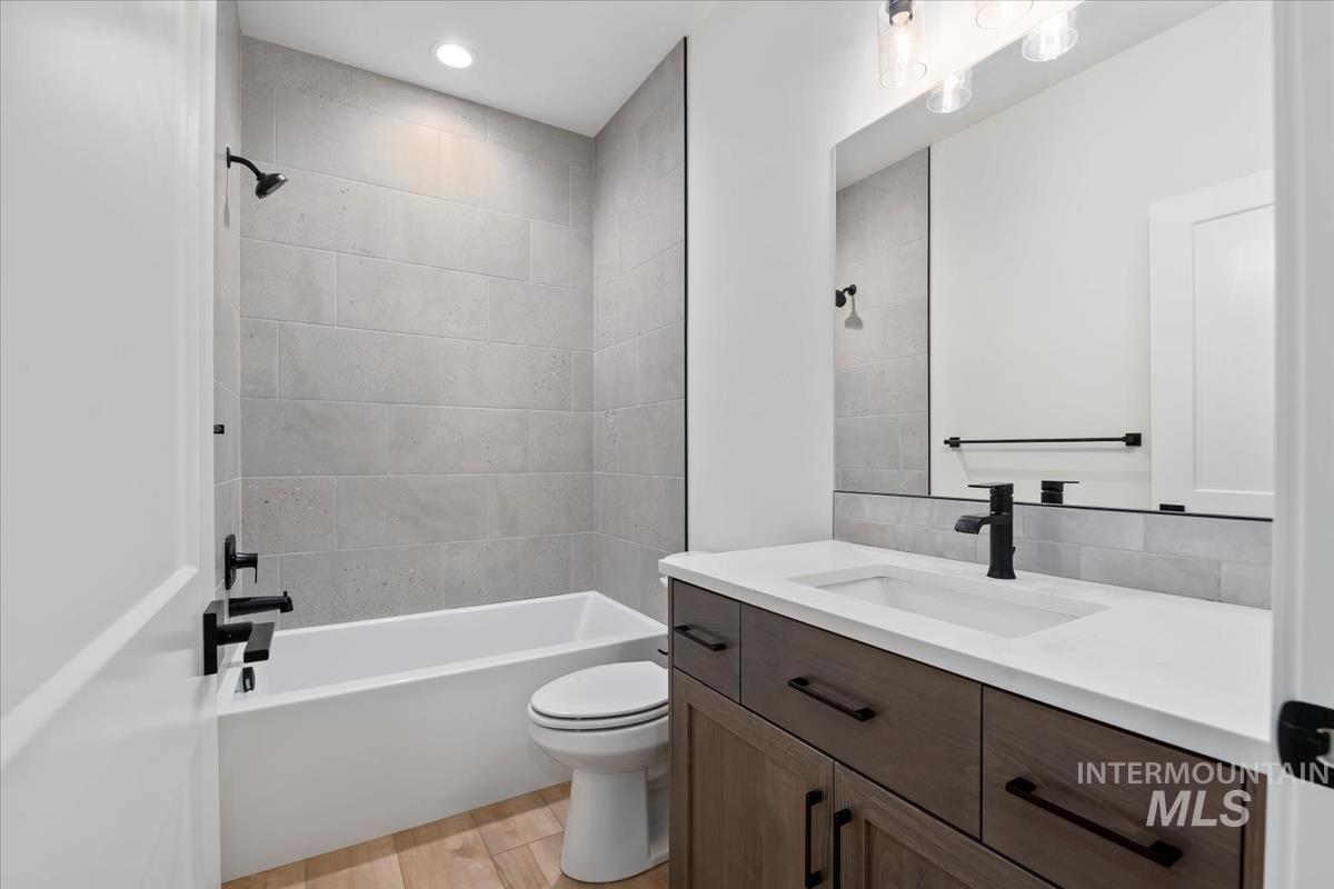 Full bathroom with vanity, tub / shower combination, and light wood-style floors