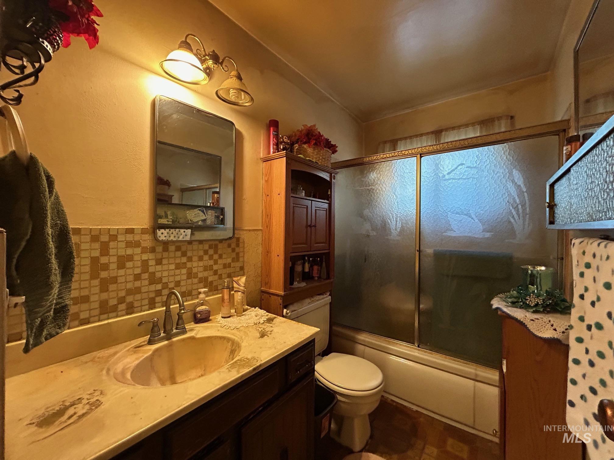 Full bathroom with combined bath / shower with glass door and vanity