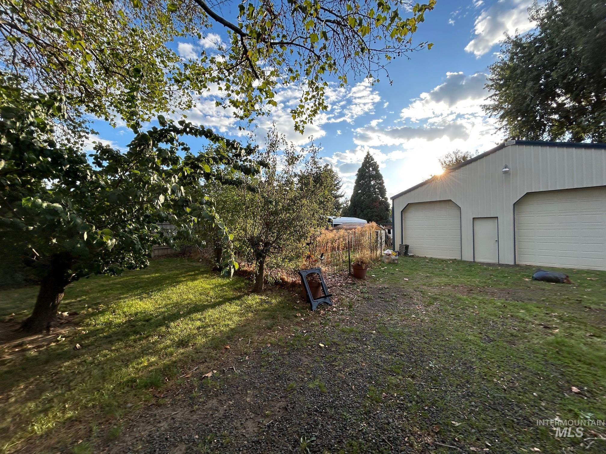 View of grassy yard with an outdoor structure and a detached garage