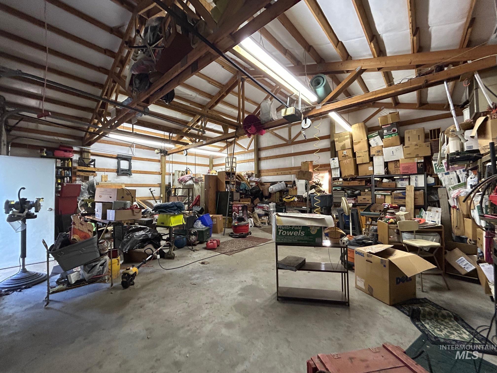 Garage featuring a workshop area, a garage door opener, and metal wall