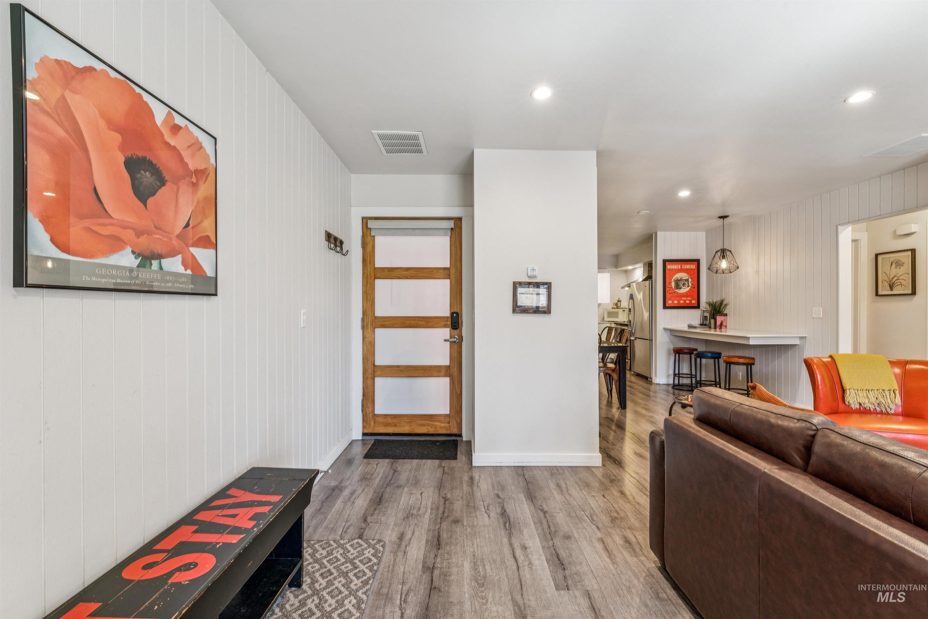 Foyer entrance with wood walls, recessed lighting, and light wood finished floors