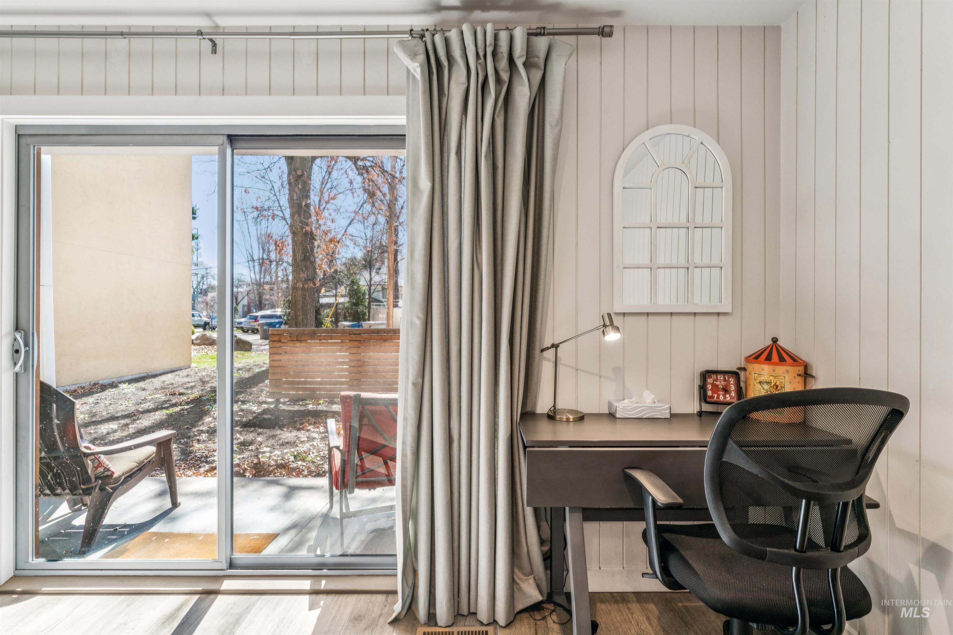 Doorway to outside with an office area, wood finished floors, and wood walls