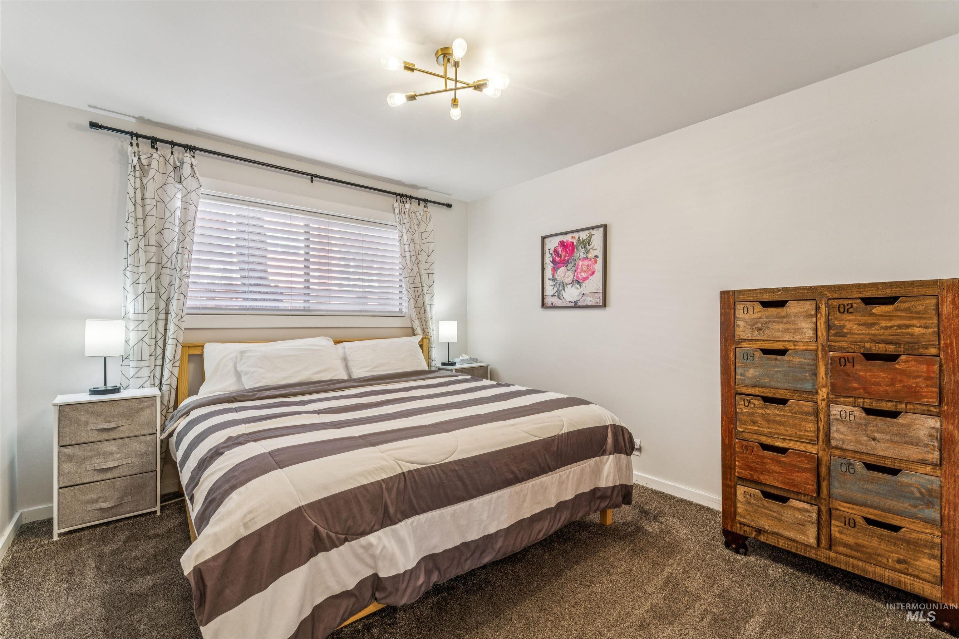 Bedroom featuring dark carpet and hanging lights