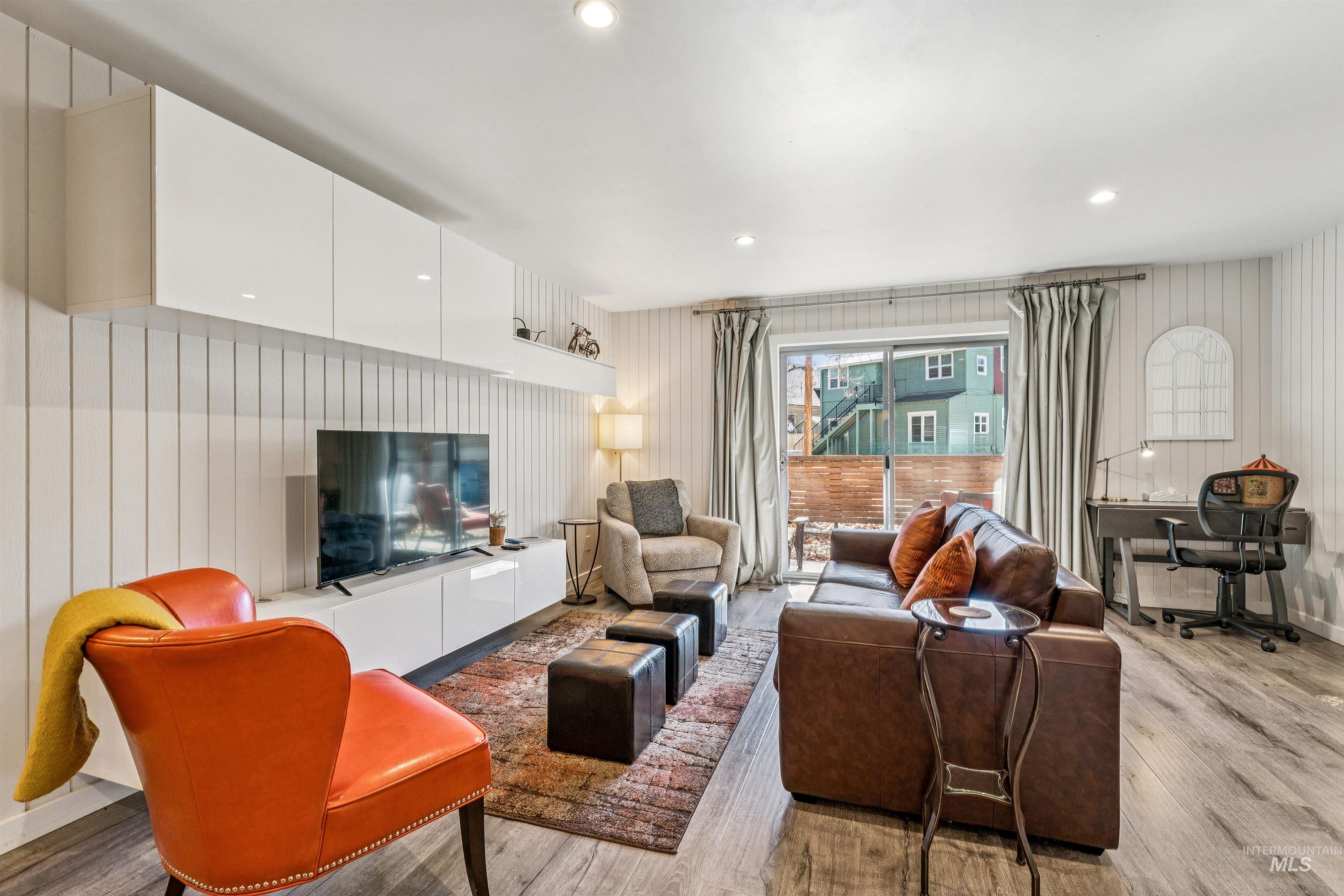 Living area with light wood finished floors and recessed lighting