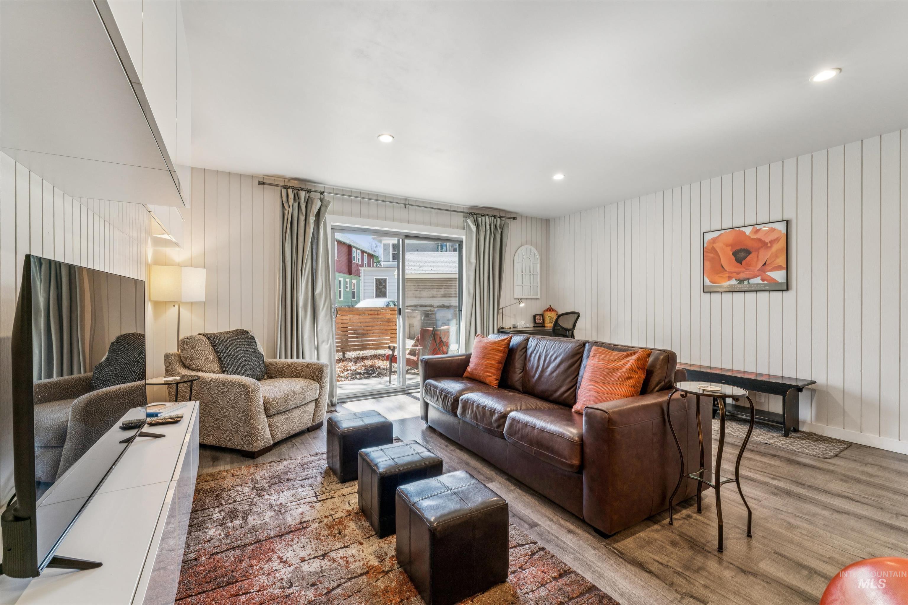 Living room featuring wood finished floors, recessed lighting, and wooden walls