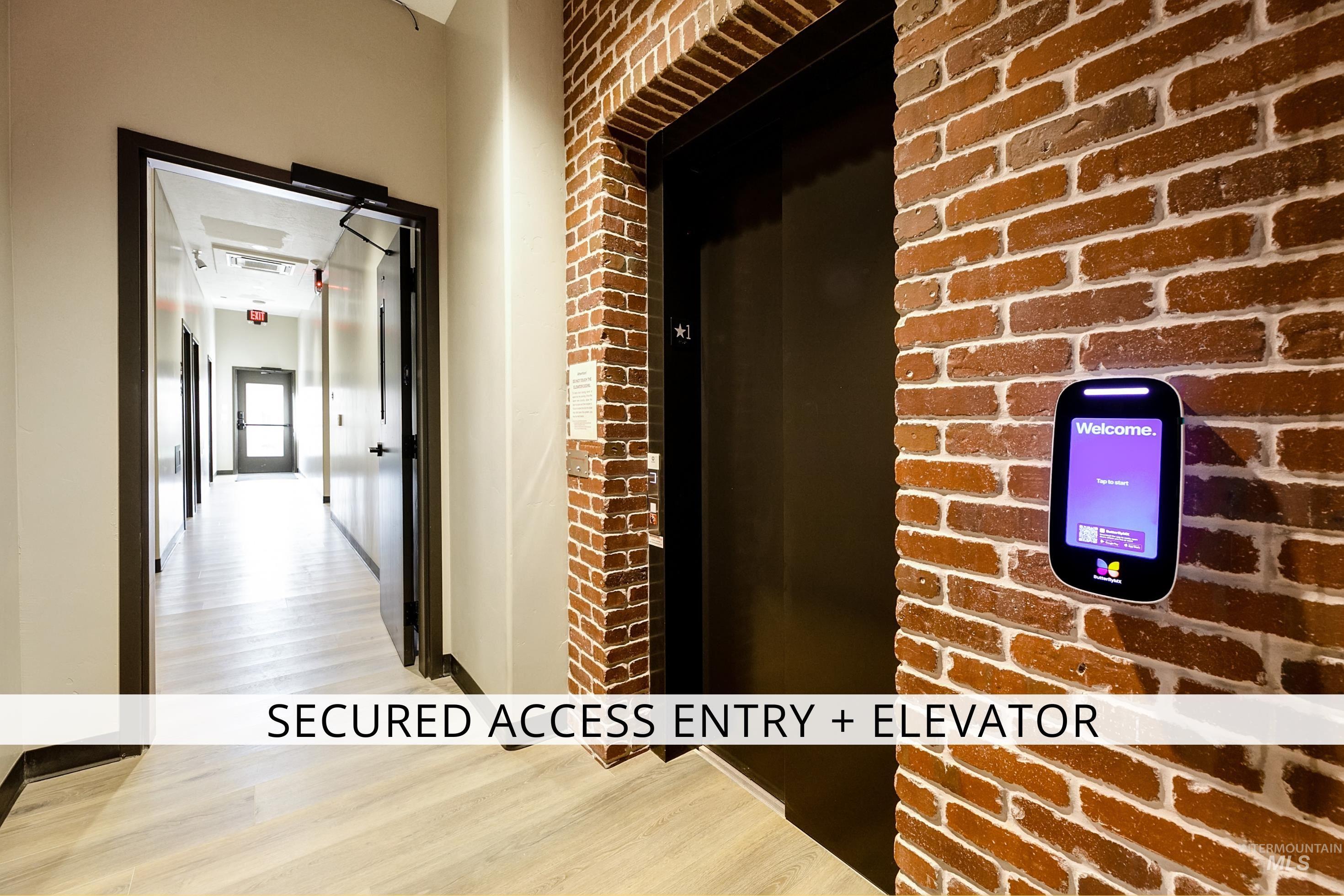 Corridor with brick wall and light wood-type flooring