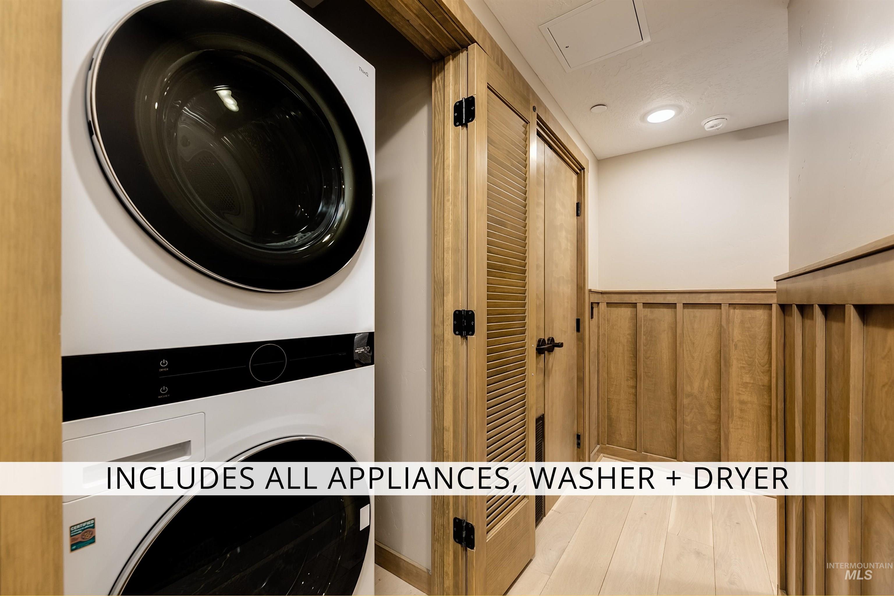 Laundry area featuring stacked washer / dryer, wainscoting, and recessed lighting