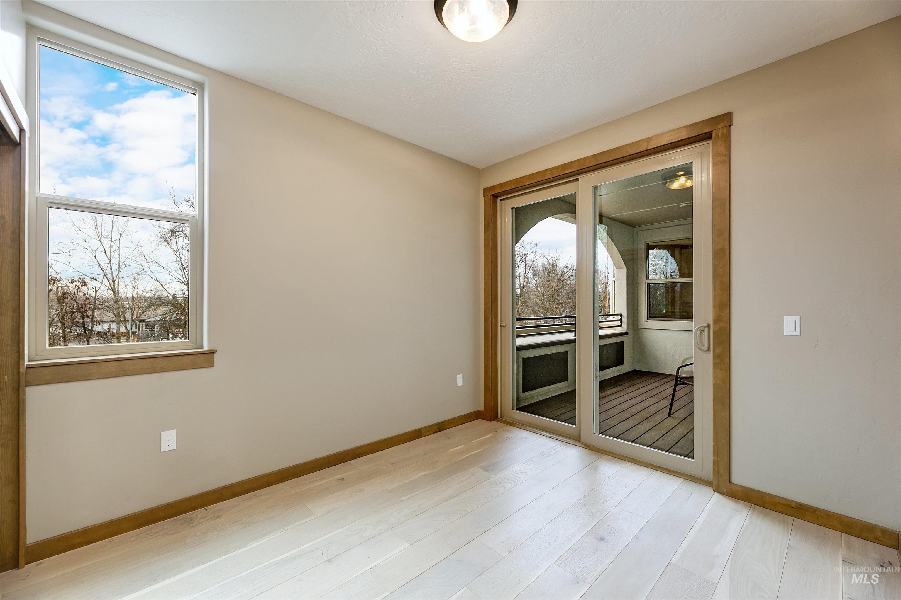 Unfurnished room with light wood-style floors and baseboards