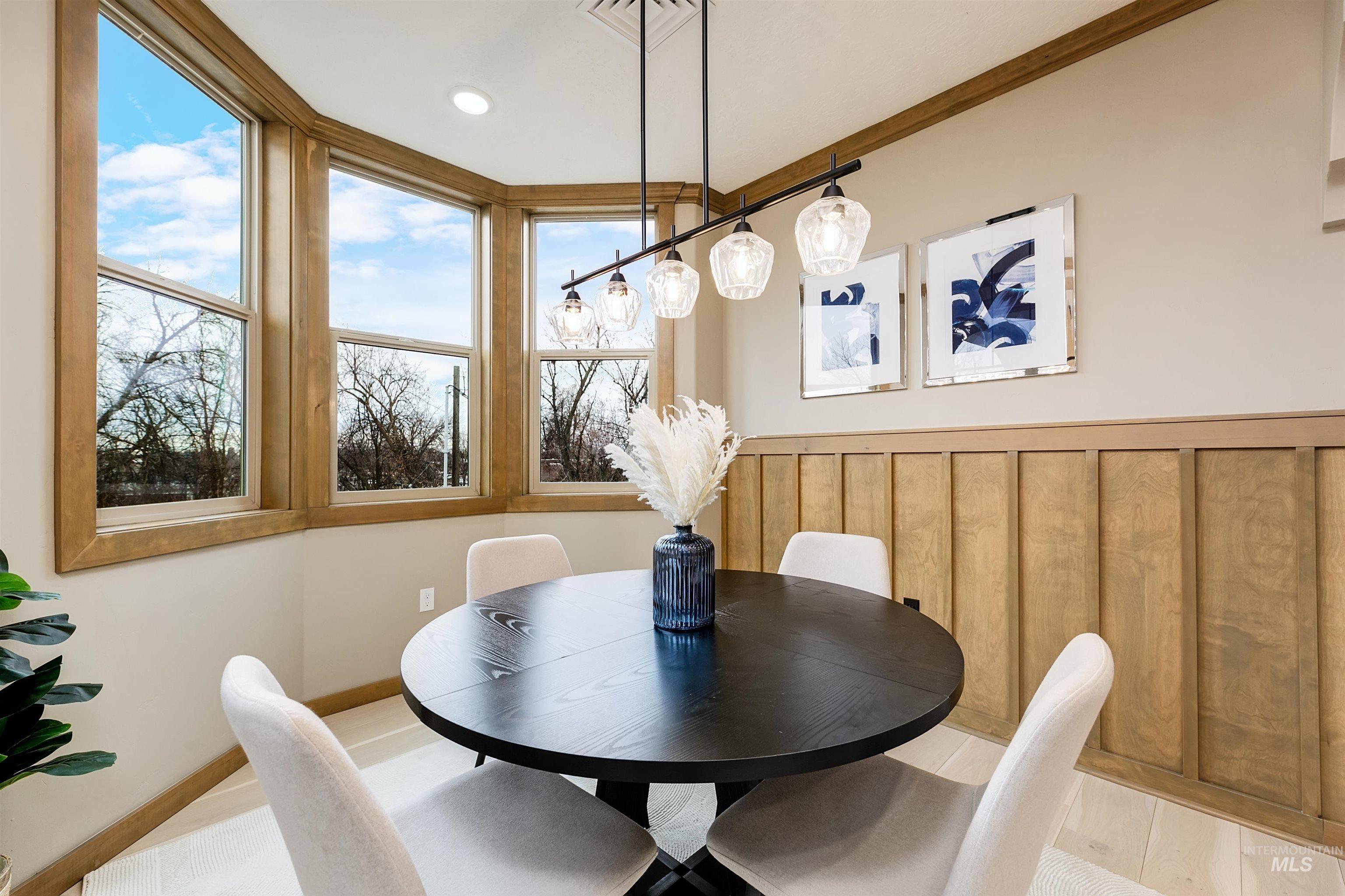 Dining space with crown molding and light wood-style flooring