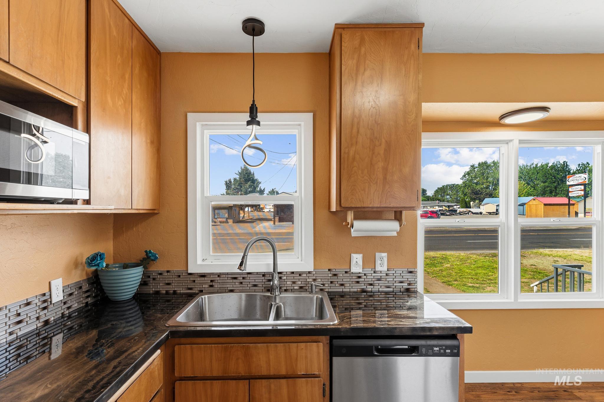 Kitchen featuring wood cabinetry, stainless steel microwave, and stainless steel dishwasher