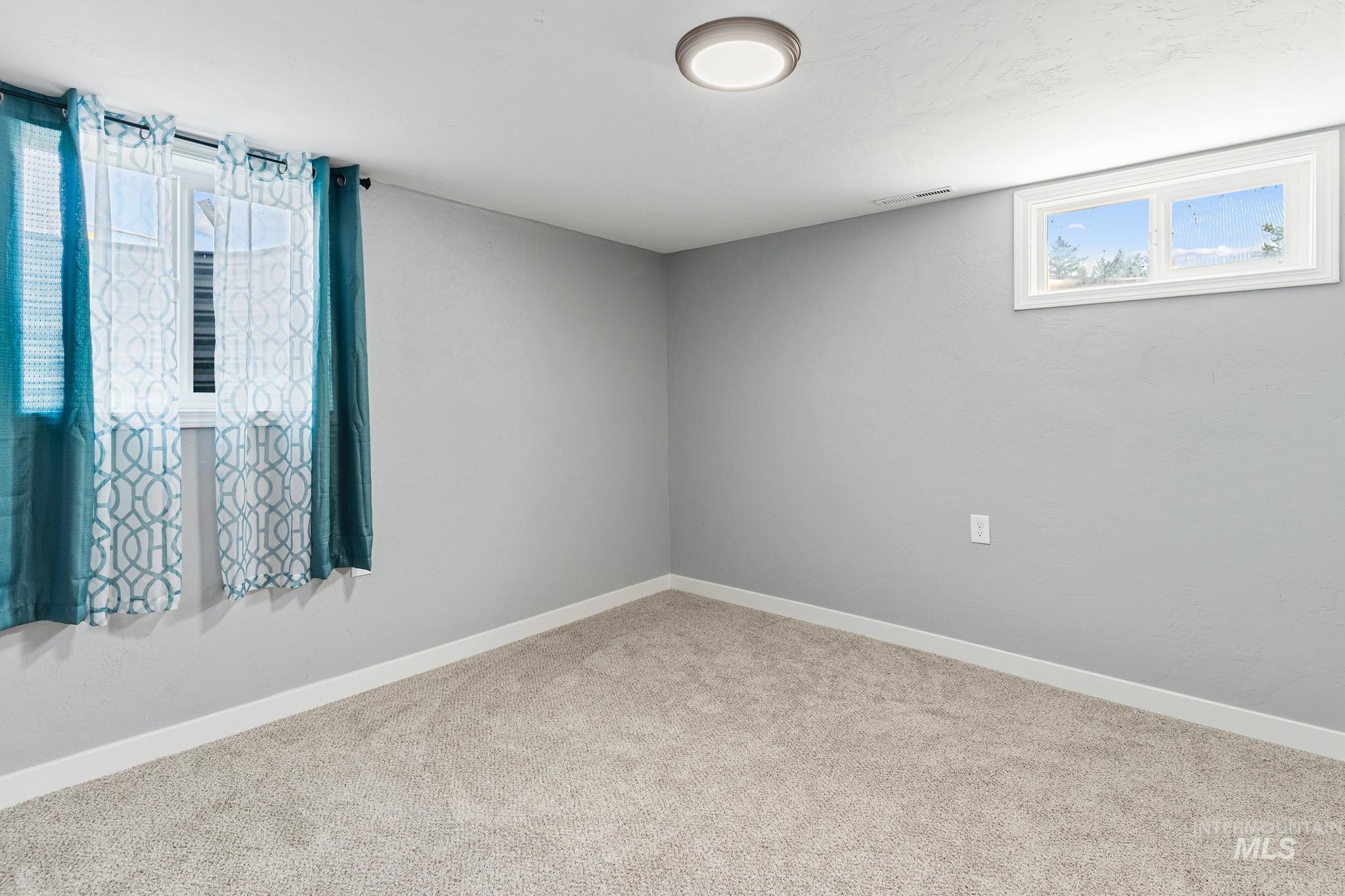 Light gray walls with white trim and neutral carpet flooring