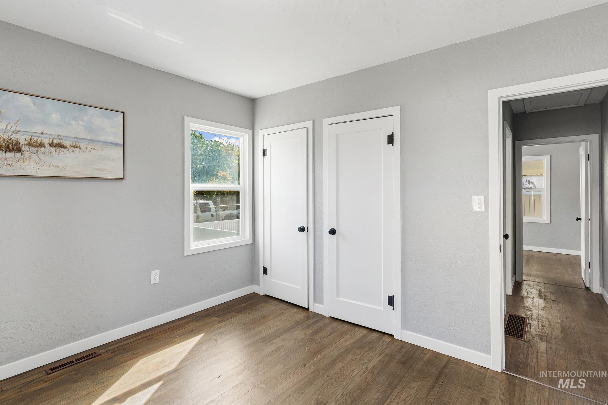 Interior room featuring wood-finish flooring, light gray walls, and white trim