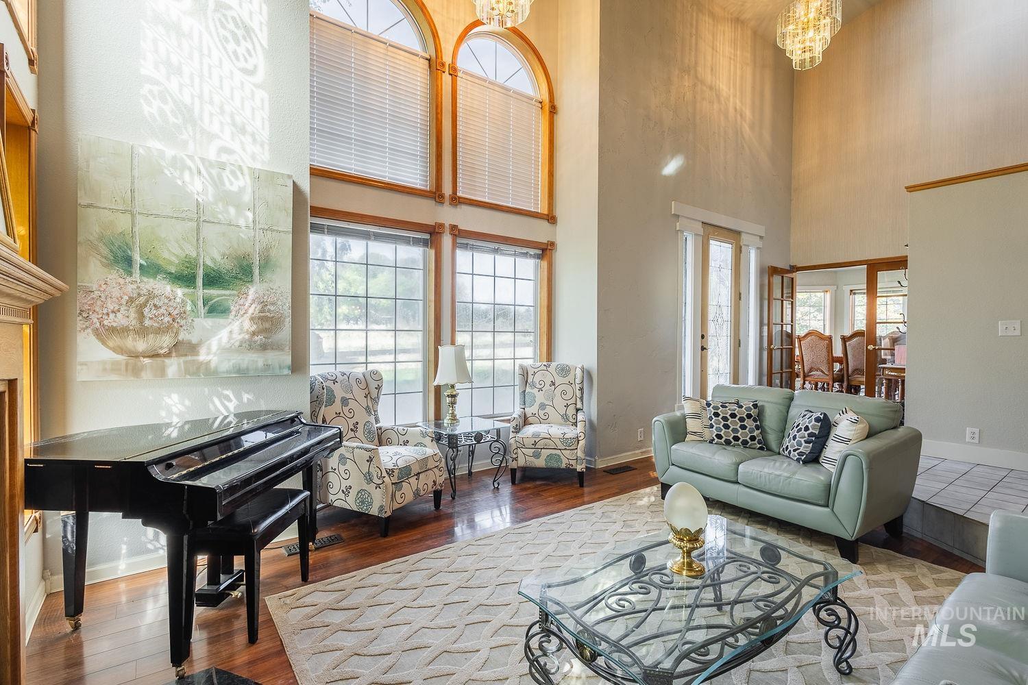 Living room featuring a chandelier, a high ceiling, and wood finished floors