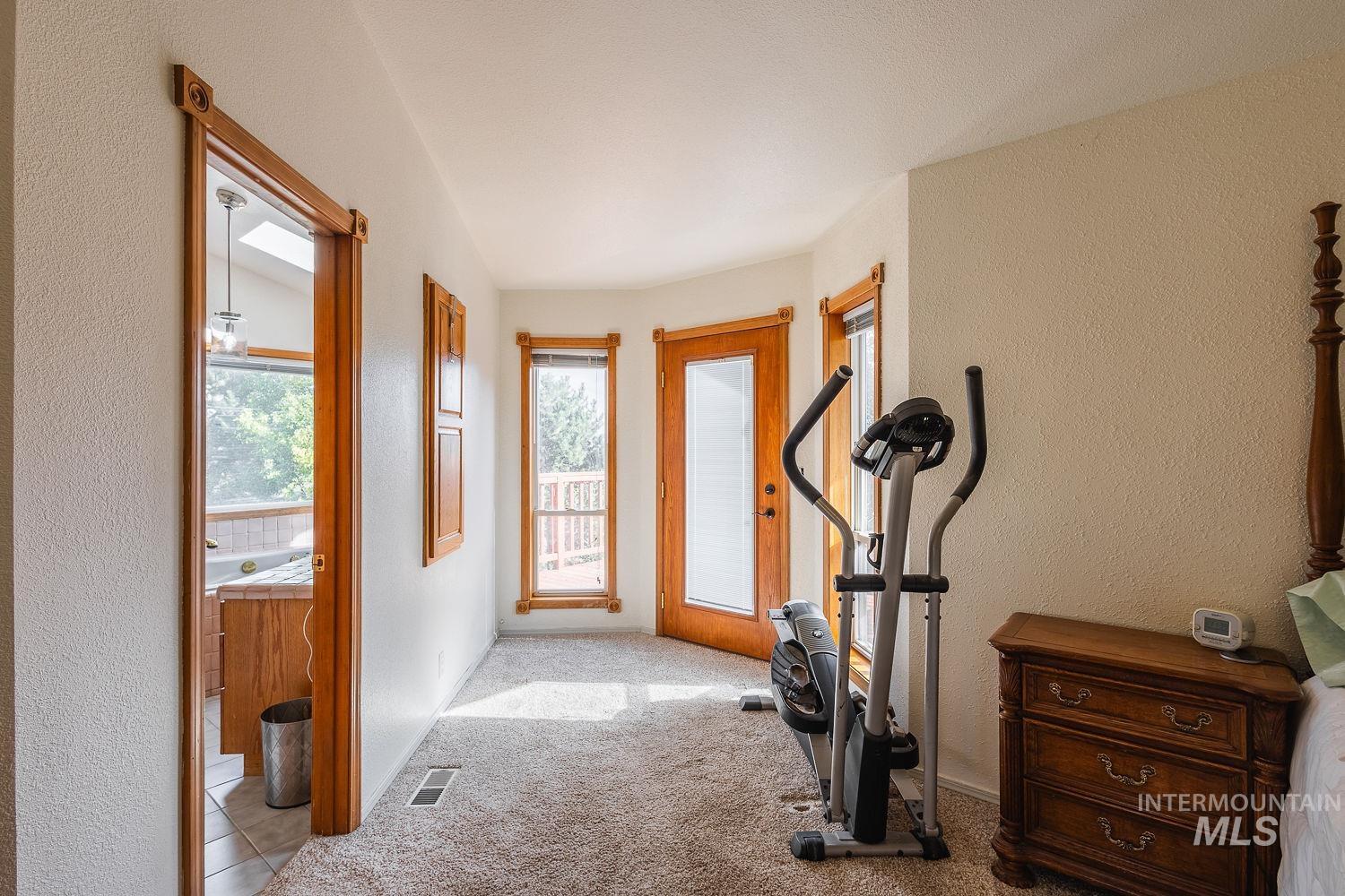 Exercise room with a textured wall and carpet floors