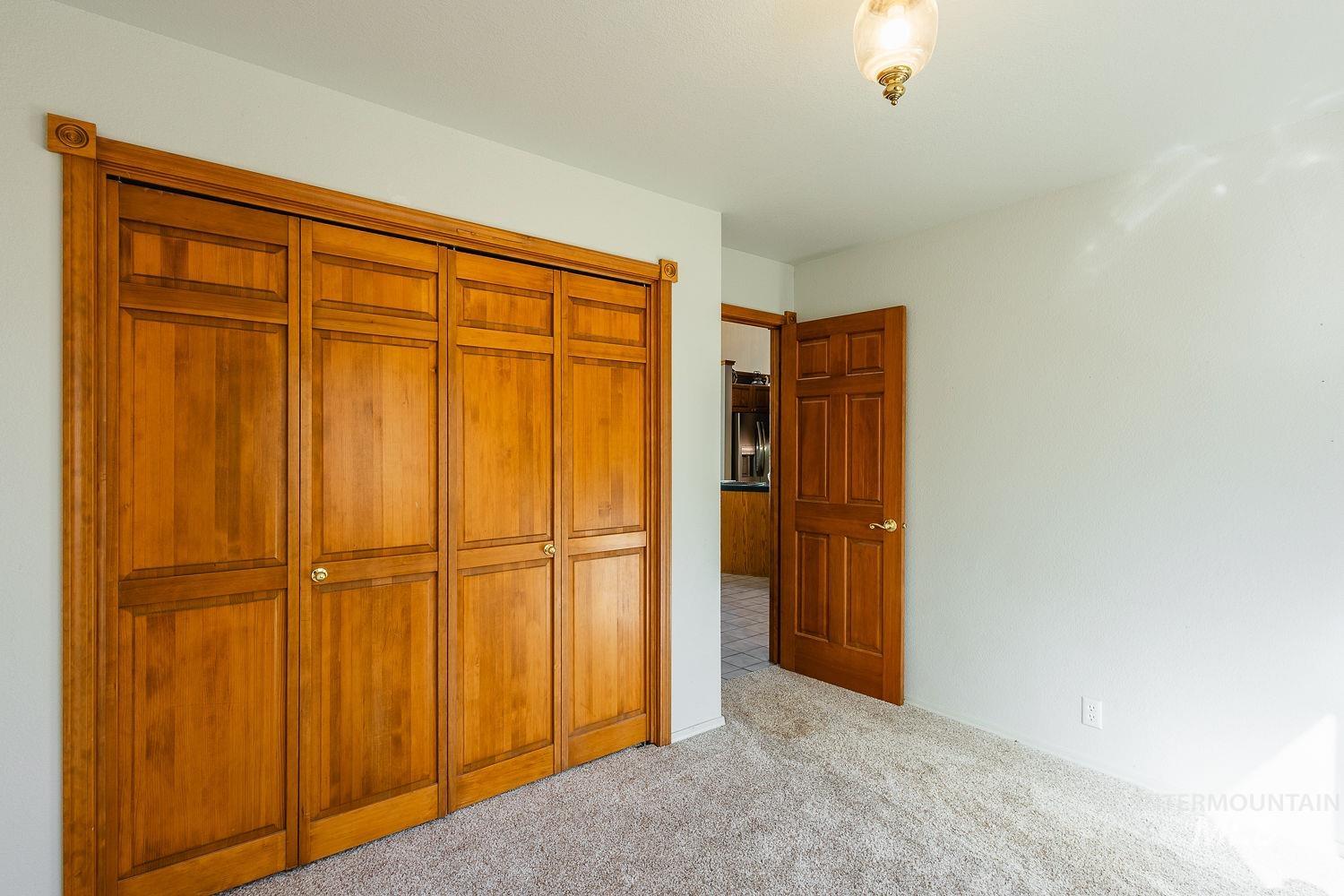 Unfurnished bedroom featuring light carpet and a closet