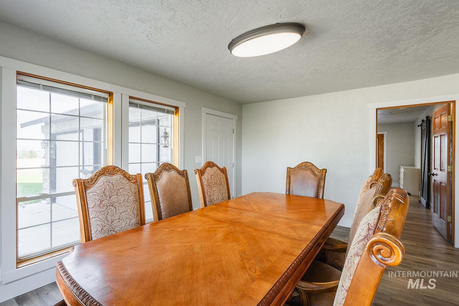 Dining area with a textured ceiling and dark wood finished floors