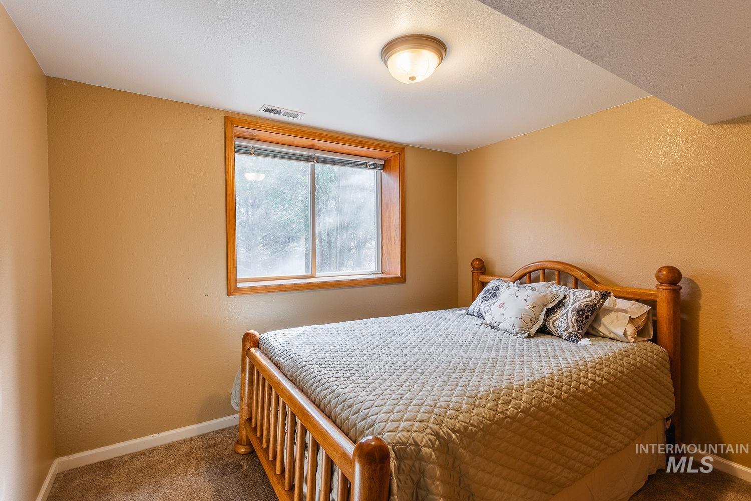 Bedroom featuring a textured wall and carpet flooring