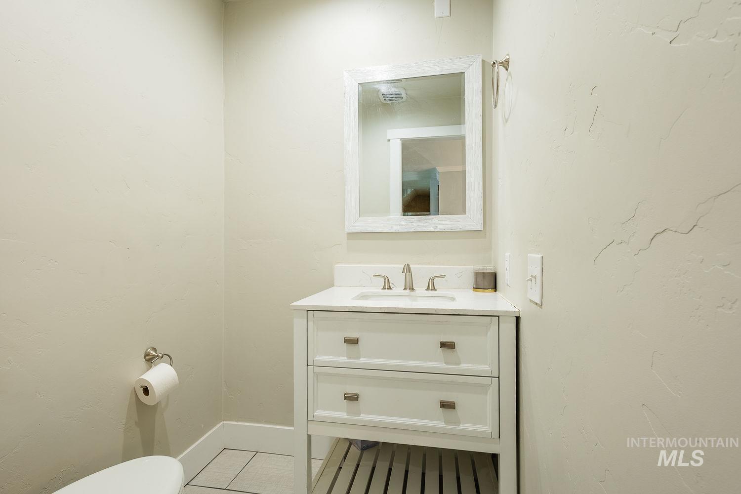 Half bath with vanity and tile patterned flooring