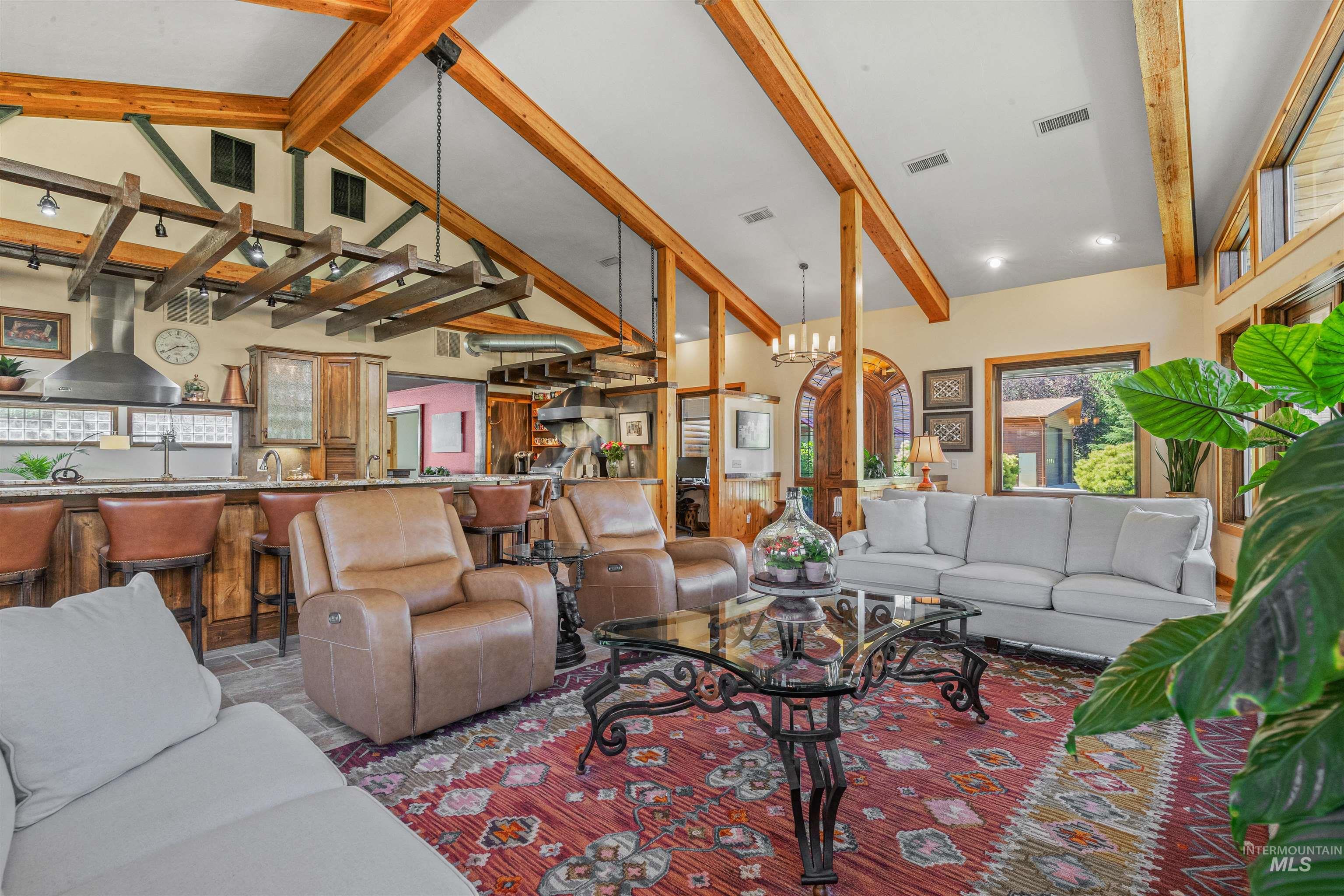 Living area with beam ceiling, high vaulted ceiling, and a chandelier