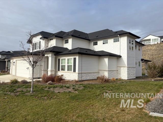 View of side of property with stone siding, a yard, and driveway
