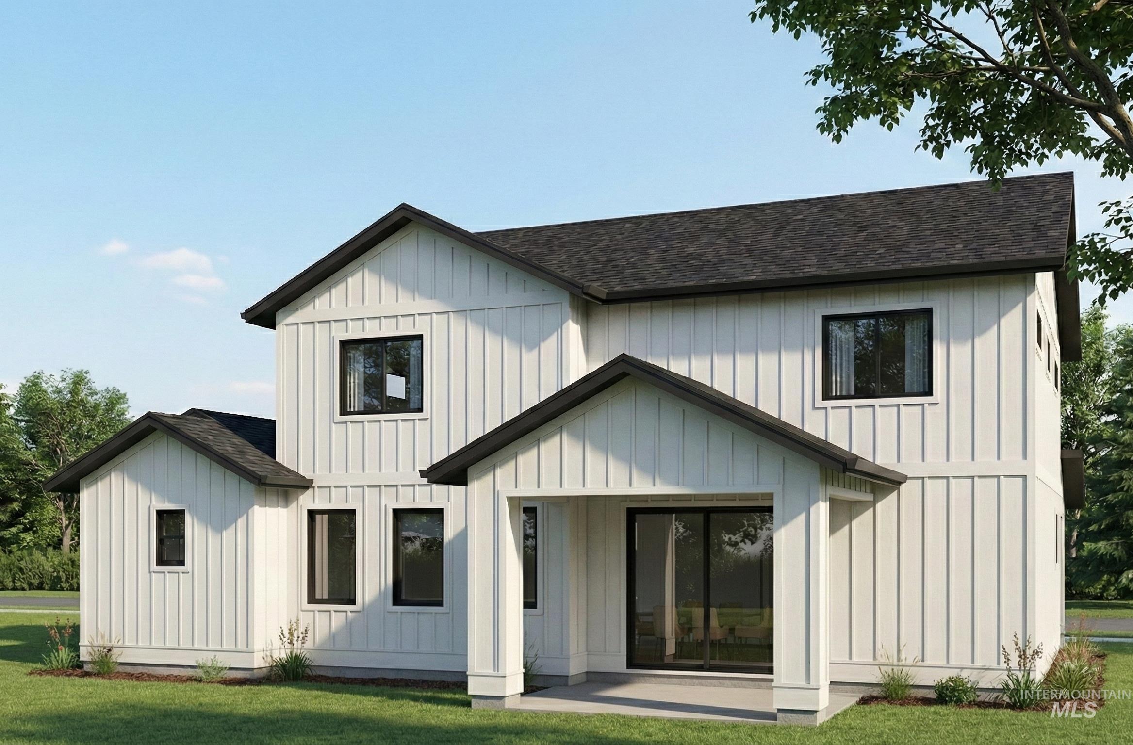 Rear view of house featuring roof with shingles, board and batten siding, and a yard