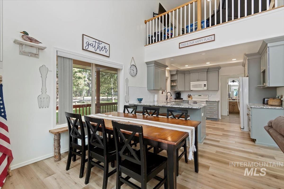 Dining area with light wood finished floors and a high ceiling