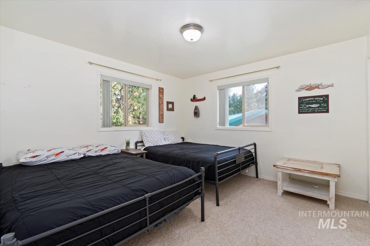 Bedroom with carpet and multiple windows