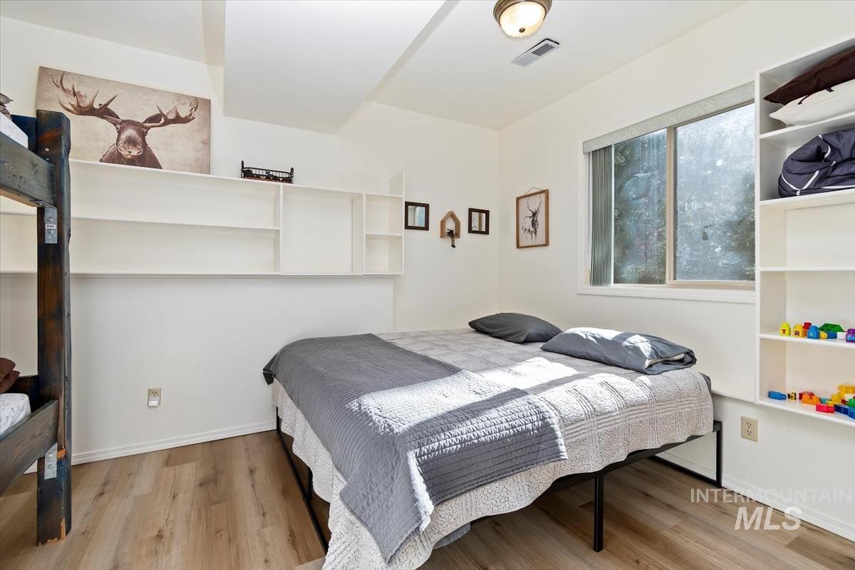 Bedroom with wood finished floors and baseboards
