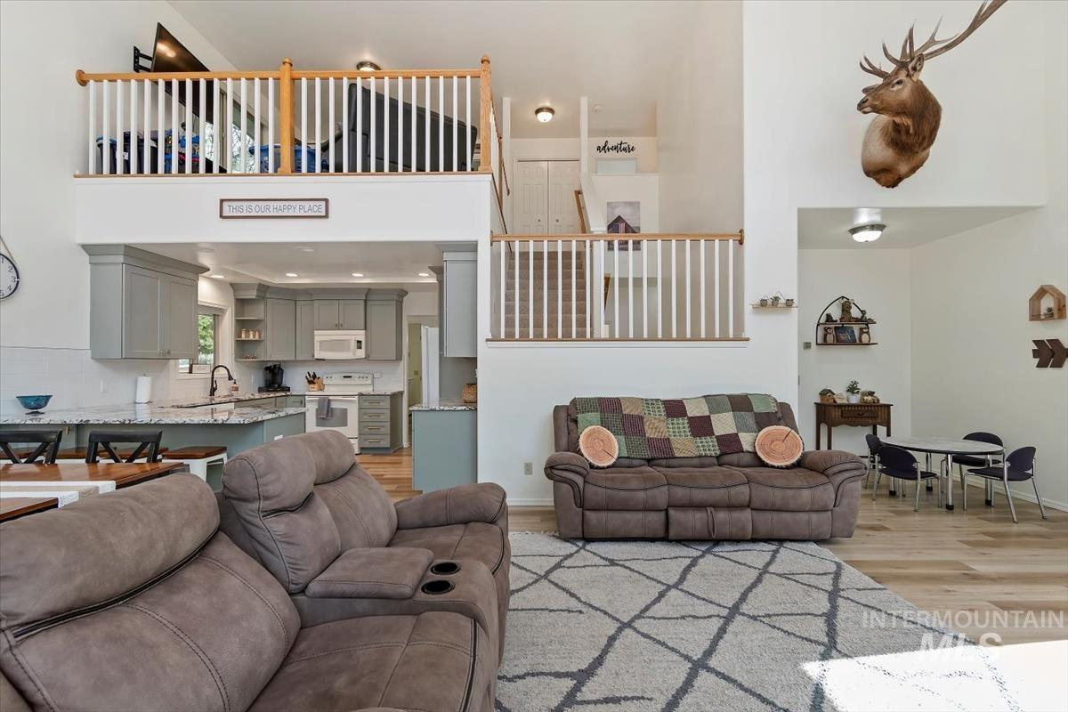 Living area featuring light wood-type flooring and a towering ceiling