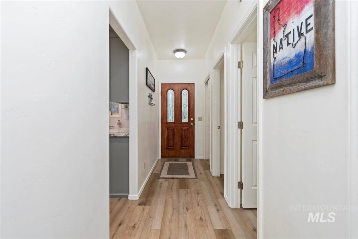 Doorway with wood finished floors and baseboards