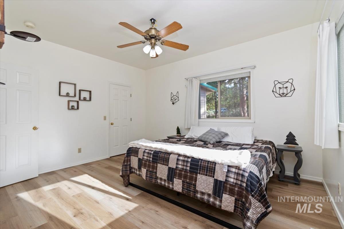 Bedroom with light wood-style floors and a ceiling fan