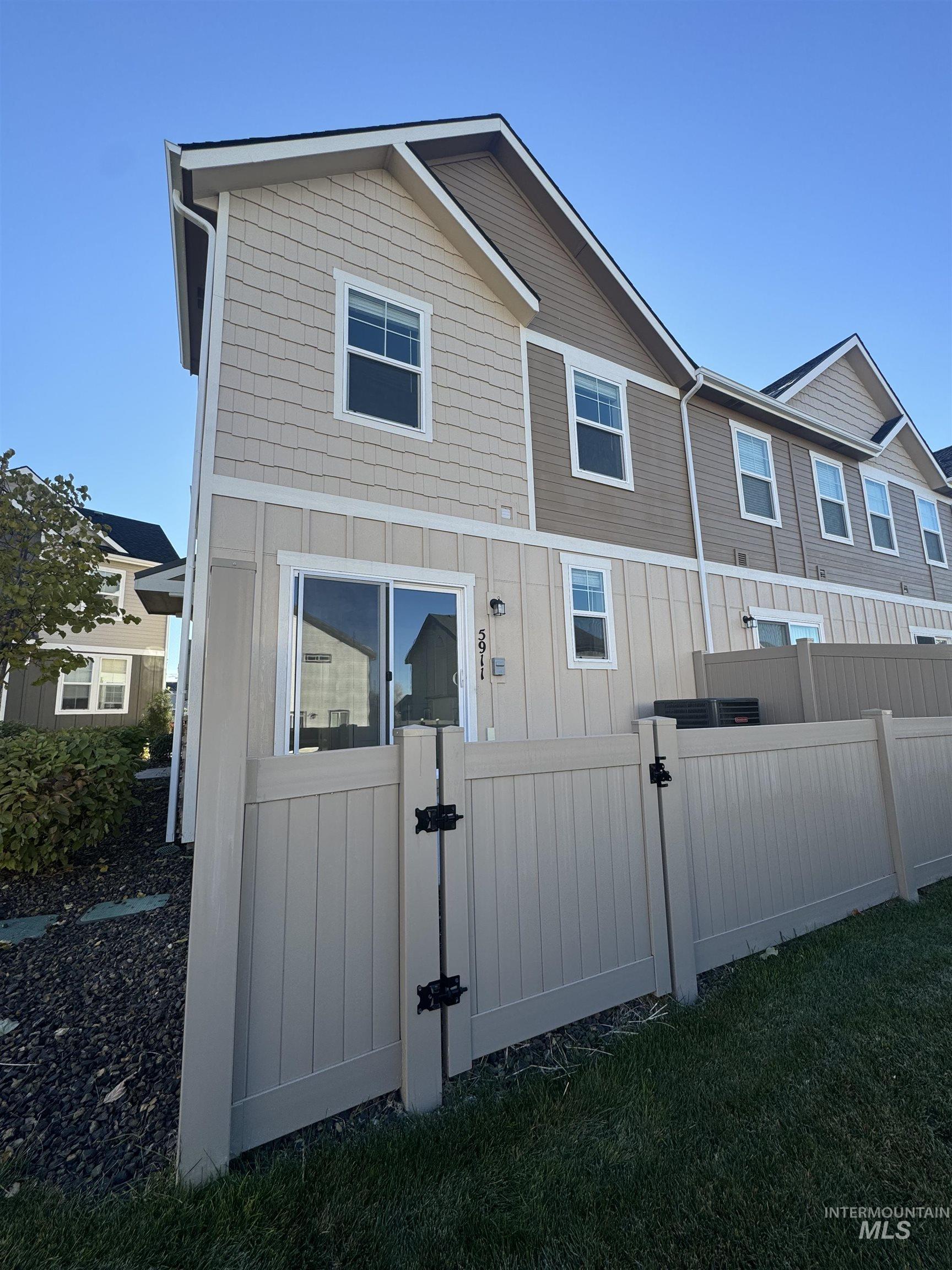 Rear view of property featuring a gate and board and batten siding