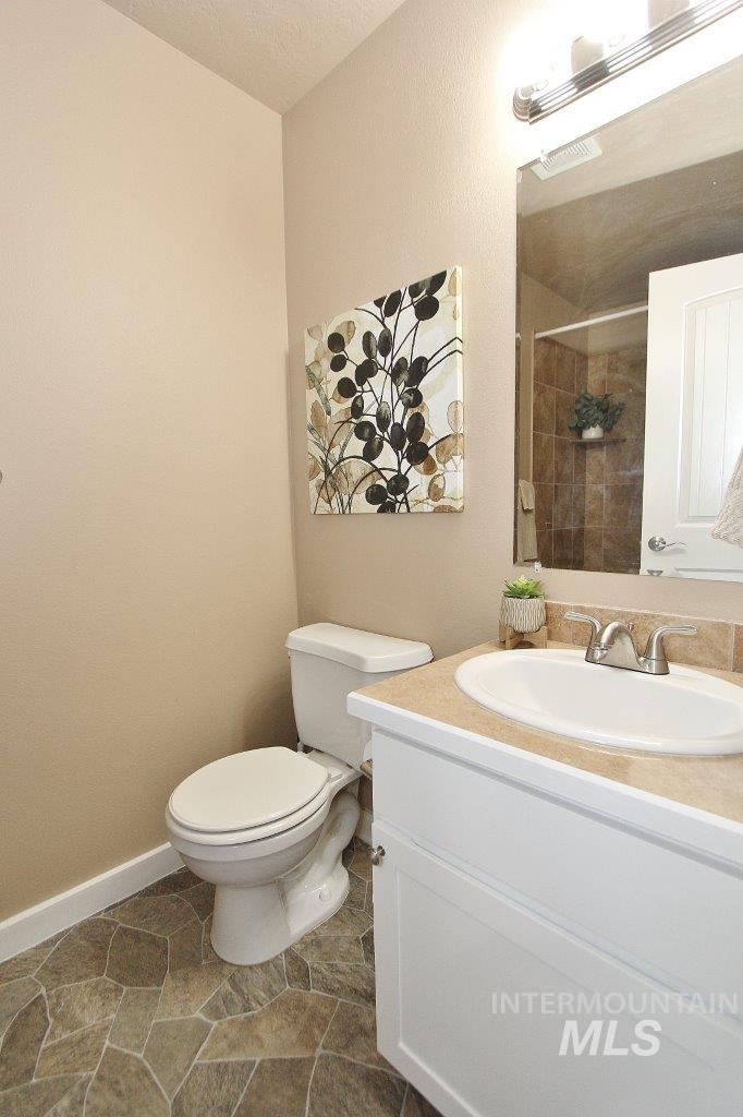 Bathroom featuring a white vanity with an integrated sink, a neutral countertop, and a chrome faucet