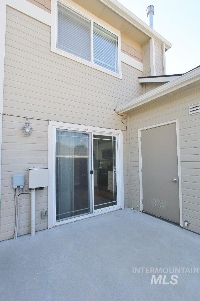 Private patio featuring a sliding glass door and an exterior storage door