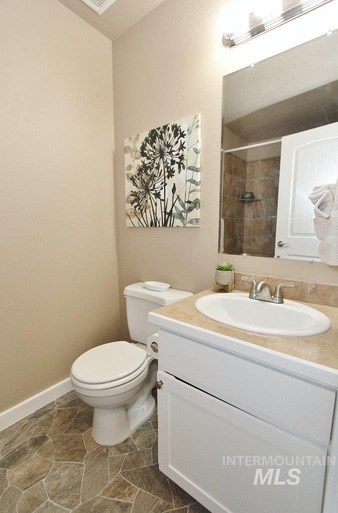 Bathroom featuring a white vanity with an integrated sink, a light-colored countertop, and a vanity mirror