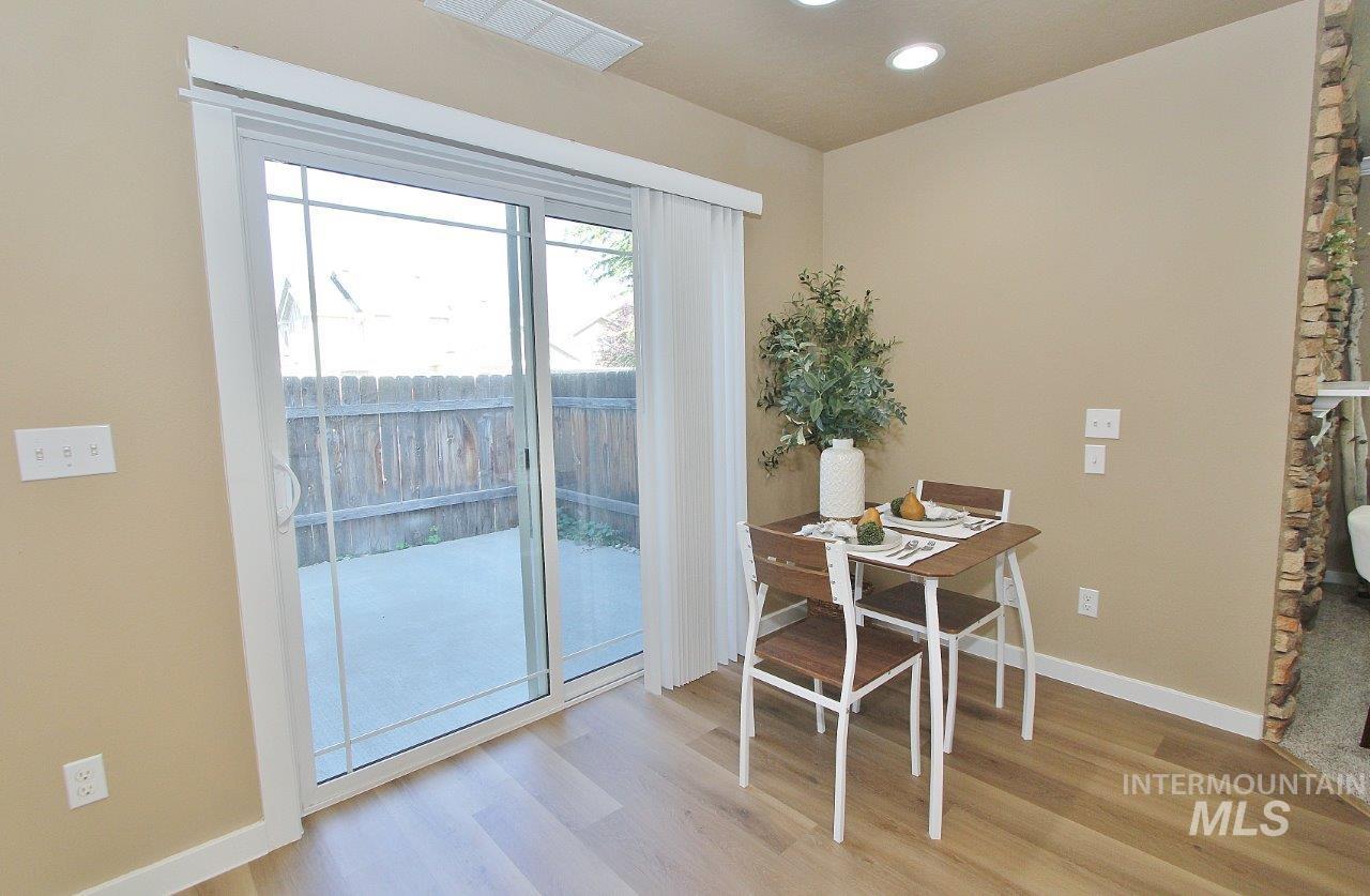 Dining area featuring wood-finish flooring, recessed lighting, and a sliding glass door providing direct access to the outdoor patio
