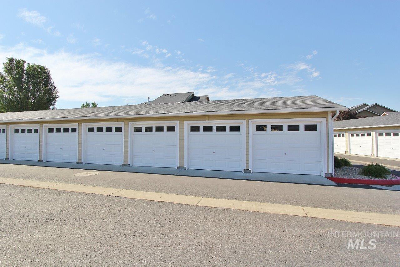 Row of attached garages featuring white overhead doors with square window inserts